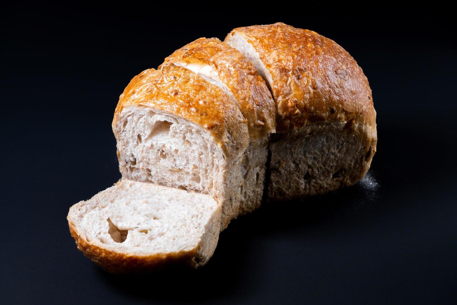 Fresh whole wheat bread with a coffee mug on black background. Healthy eating breakfast. photo