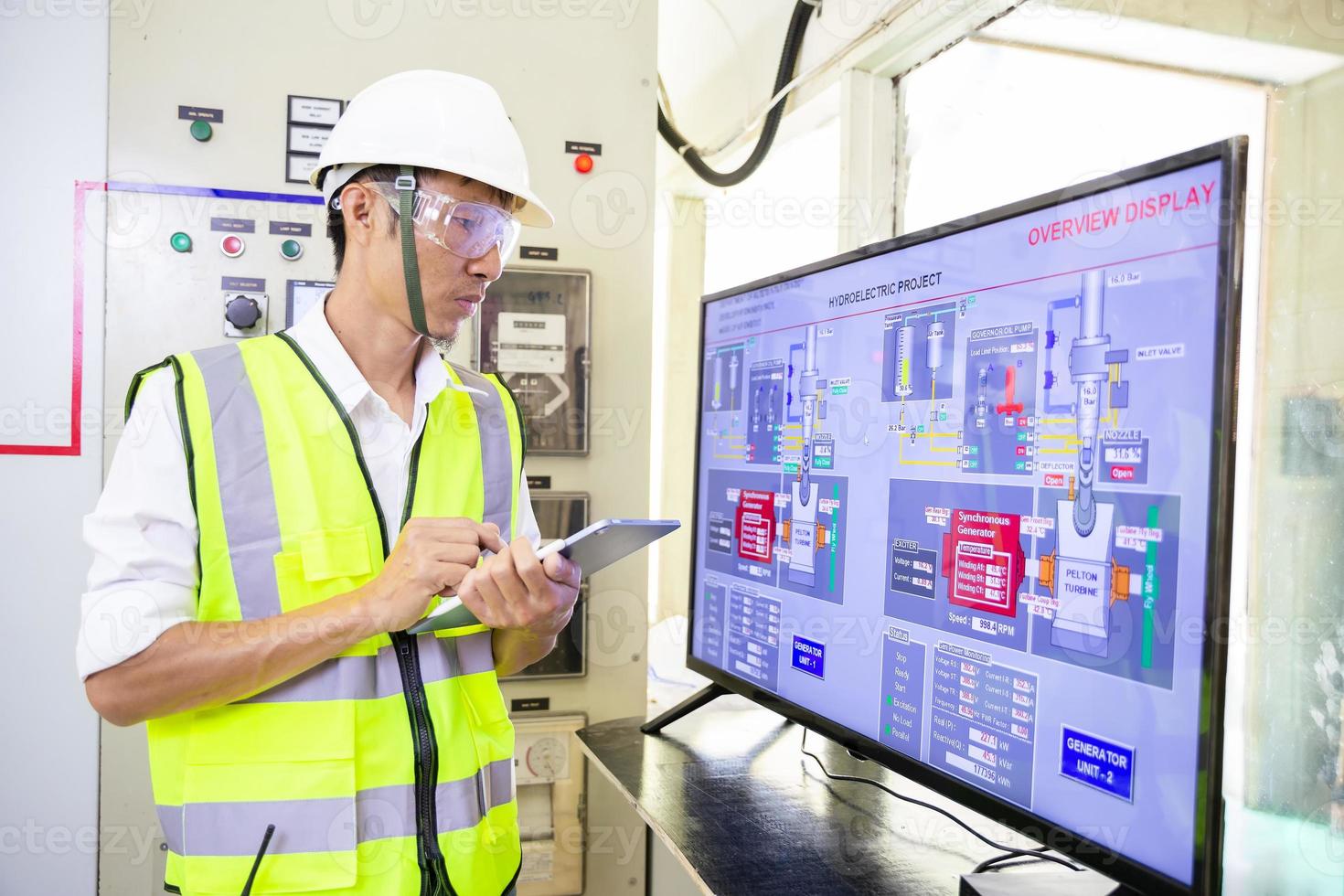 ingeniero eléctrico que trabaja con paneles de control frontales, sistema de controles de verificación diario del técnico para funciones de seguridad en la sala de servicio foto