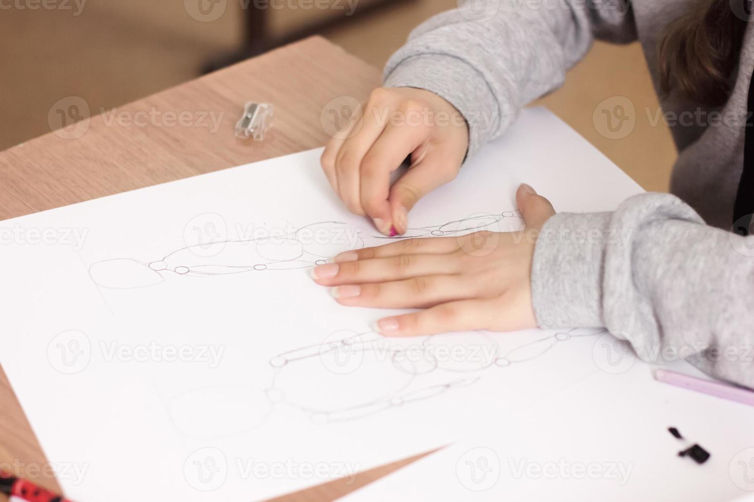 cropped view of teenager girl drawing and erasing sketch on a paper photo