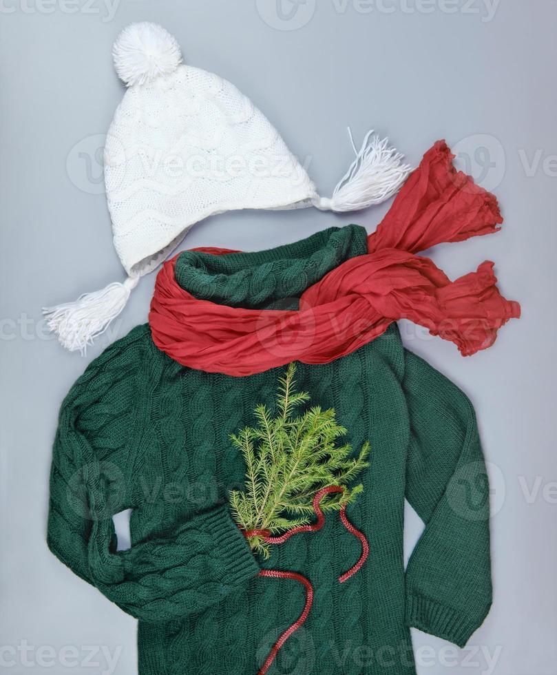dark green pullover with red scarf and white hat photo