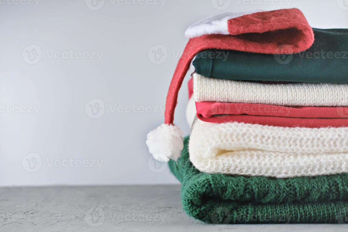 folded winter and christmas sweaters in pile photo