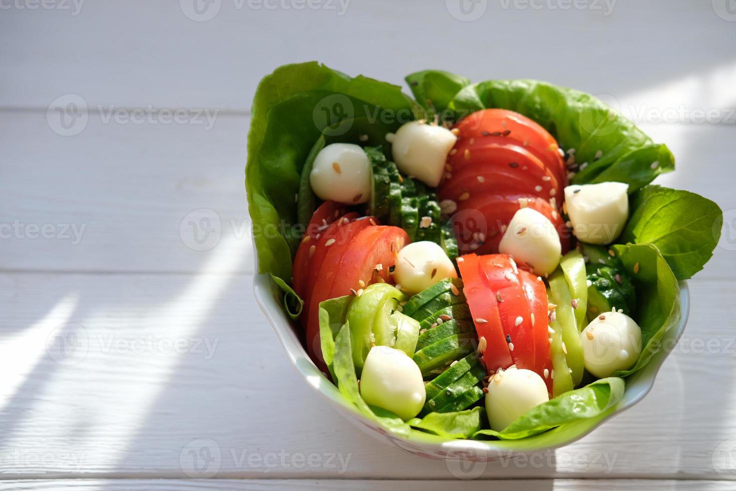 fresh vegetable salad with tomatoes, cucumbers and mozzarella cheese. photo