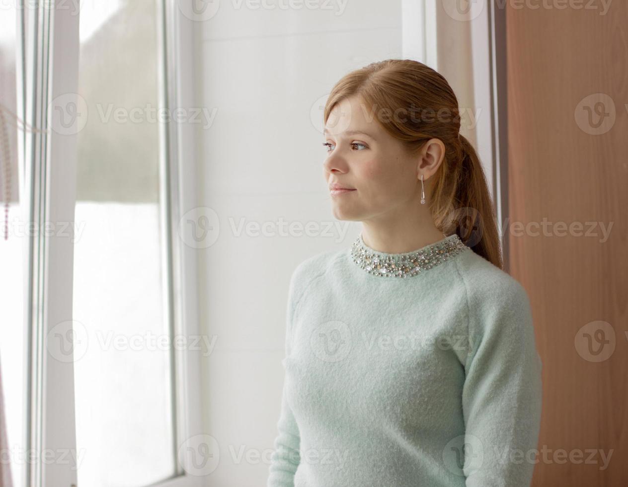 beautiful woman of middle age looking to the window. photo