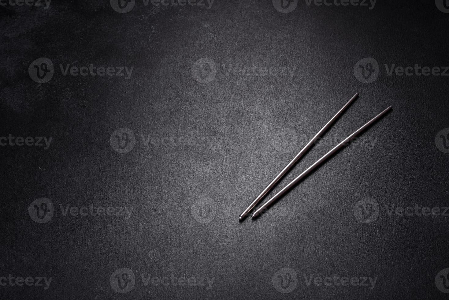 Wooden sushi sticks on a dark concrete background photo