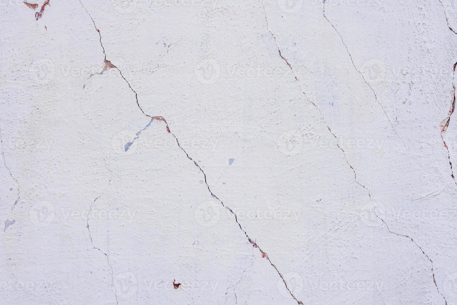 Texture of a concrete wall with cracks and scratches which can be used as a background photo