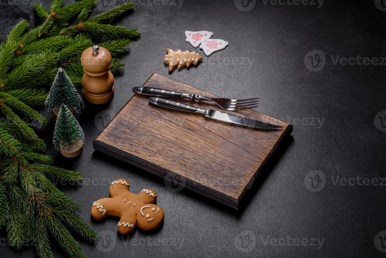 una tabla de cortar de madera vacía con cubiertos de madera en una mesa de cocina navideña foto