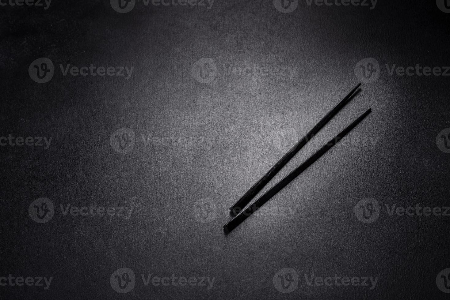 Wooden sushi sticks on a dark concrete background photo