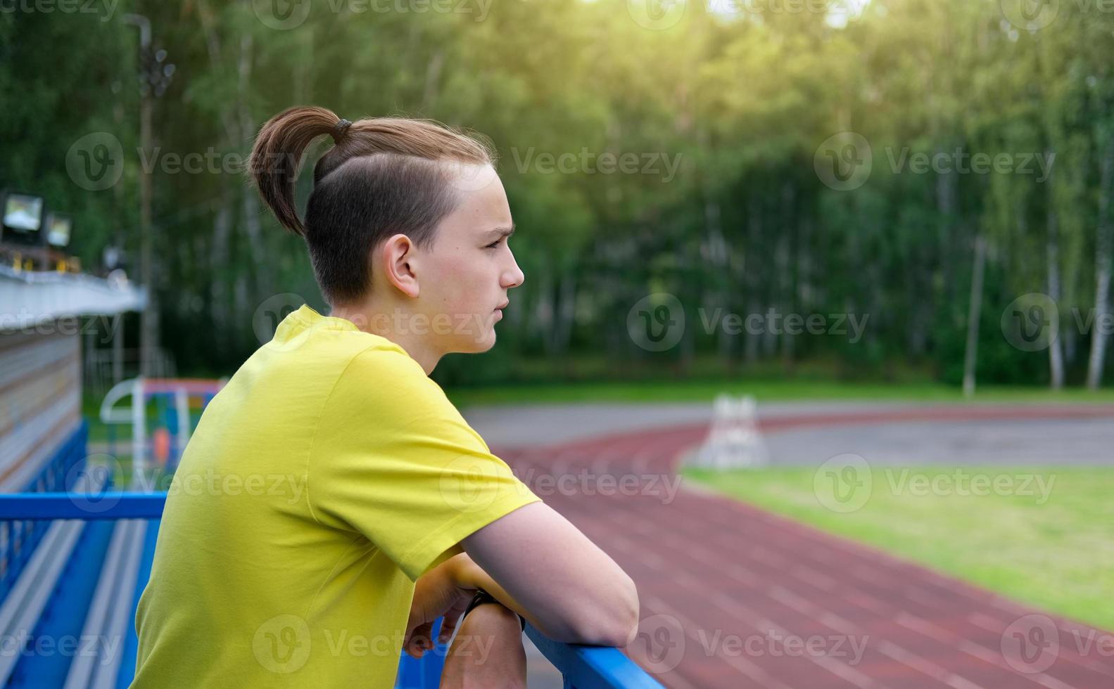 teenager boy with topknot haicut. photo