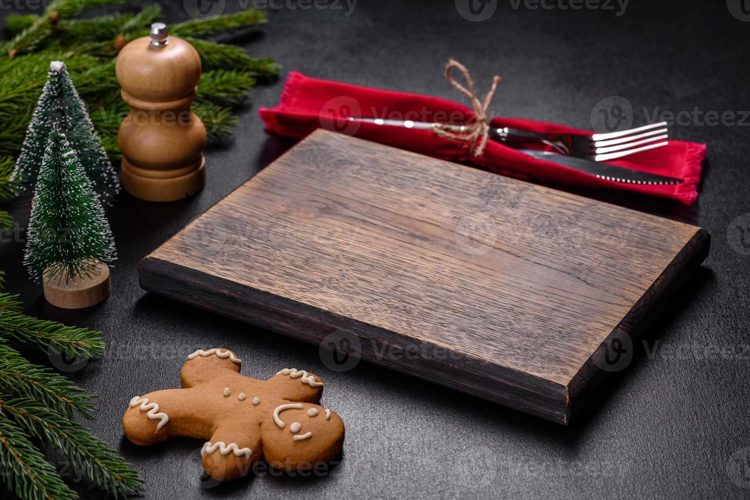 An empty wooden cutting board with wooden cutlery on a christmas kitchen table photo
