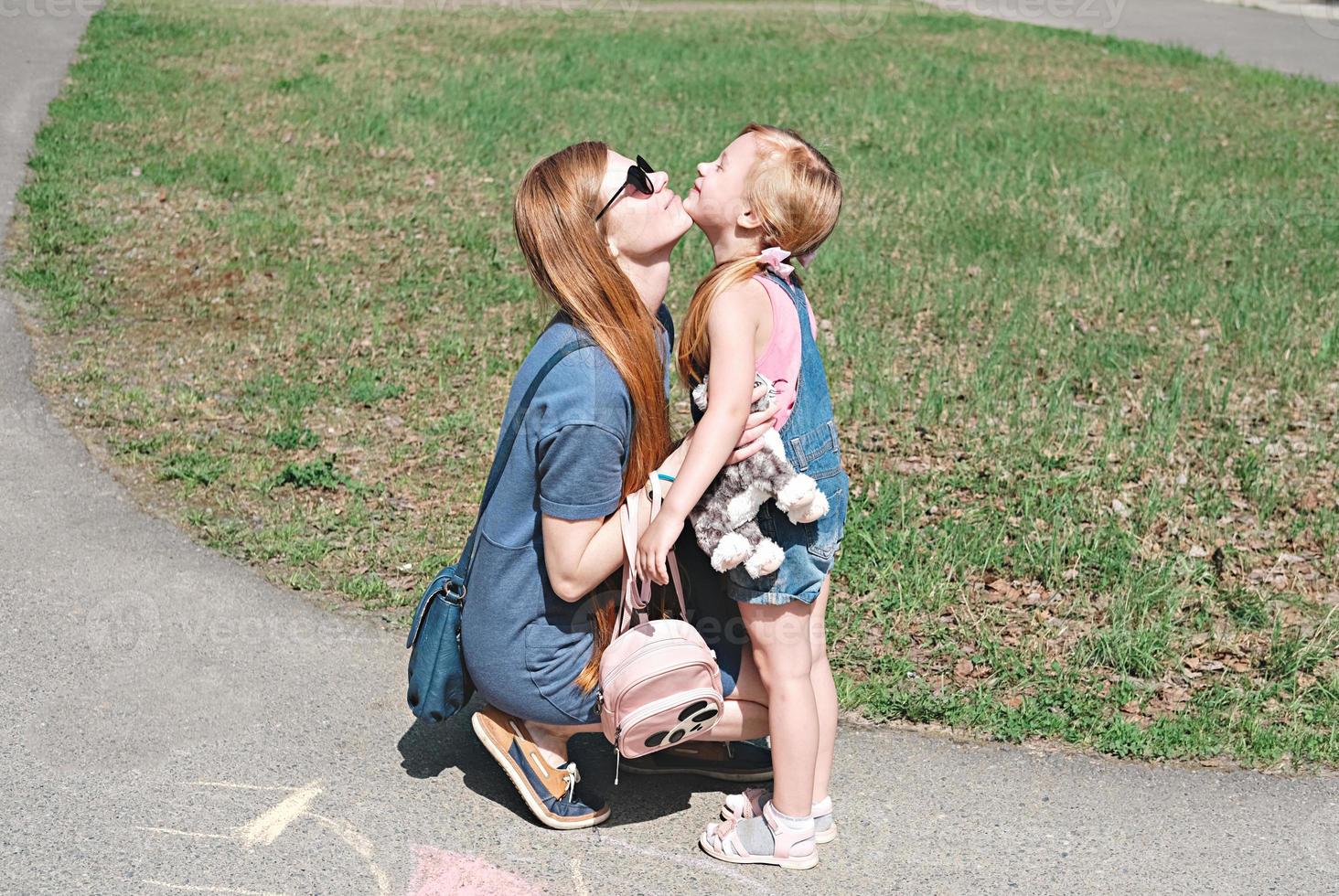 mother and daughter embracing outdoors. photo