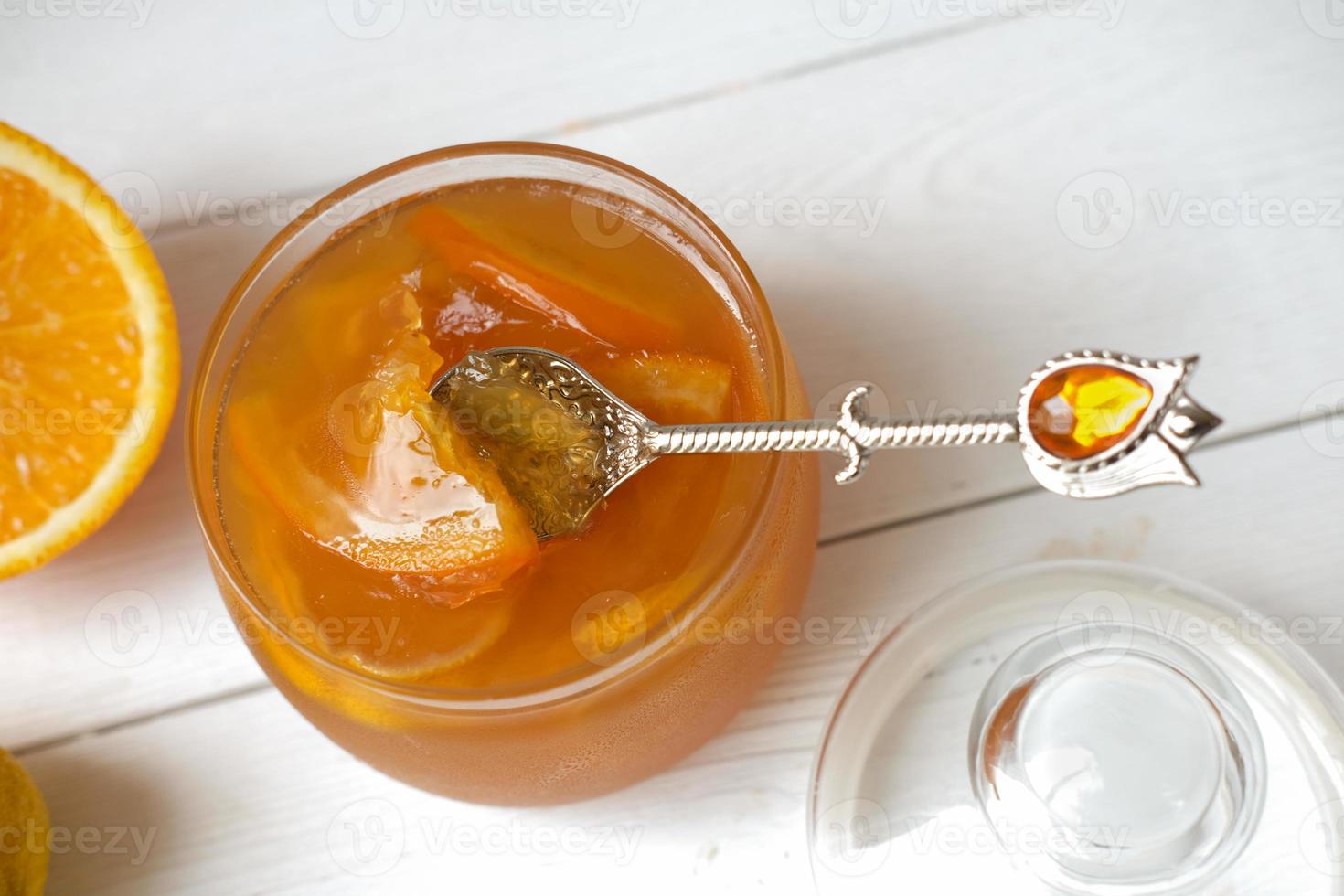 orange and lemon jelly or jam in a glass jar with spoon photo