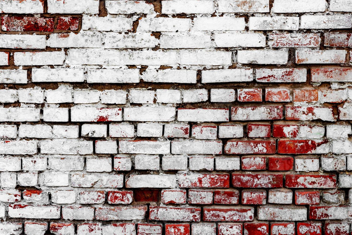 Texture of a brick wall with cracks and scratches which can be used as a background photo