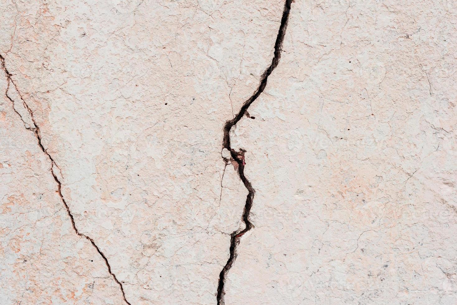 Texture of a concrete wall with cracks and scratches which can be used as a background photo