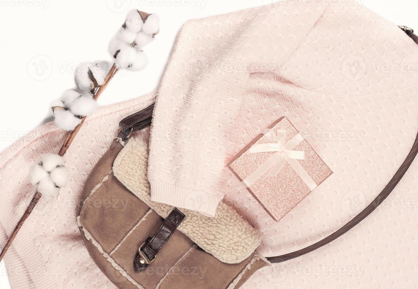 pink pullover and leather bag flat lay. photo