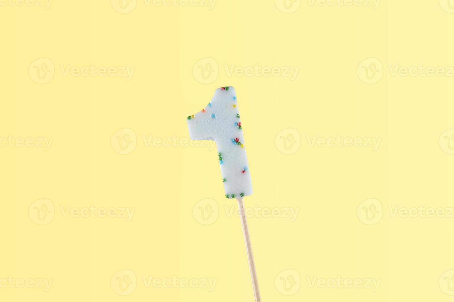 number 1 shaped lolipop on yellow background. anniversary selebration photo