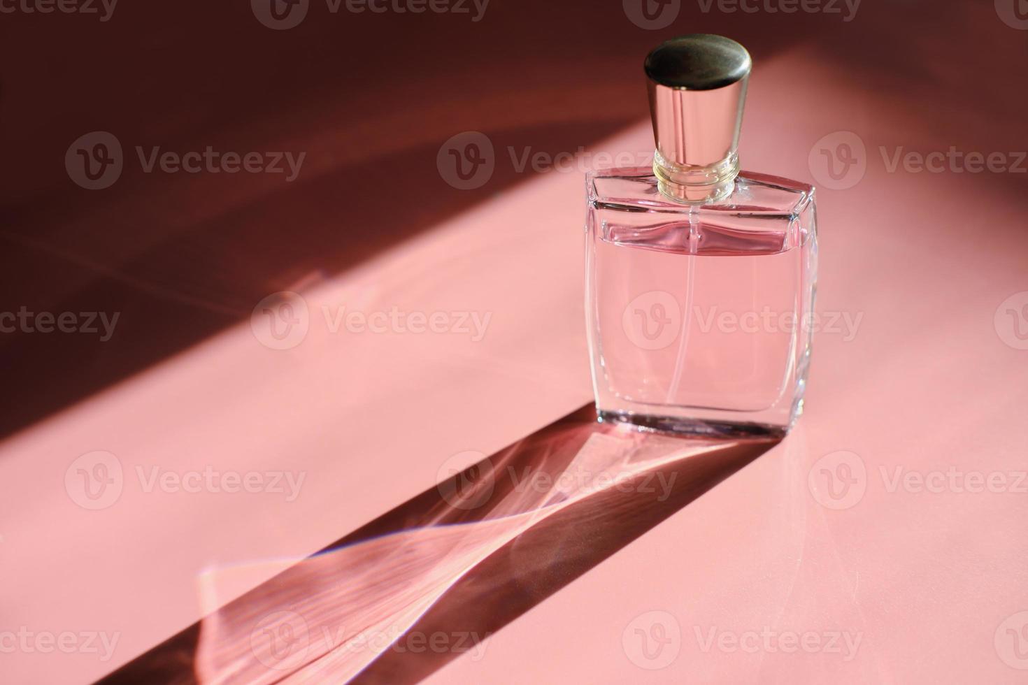 una botella de perfume con luz directa y largas sombras de colores foto