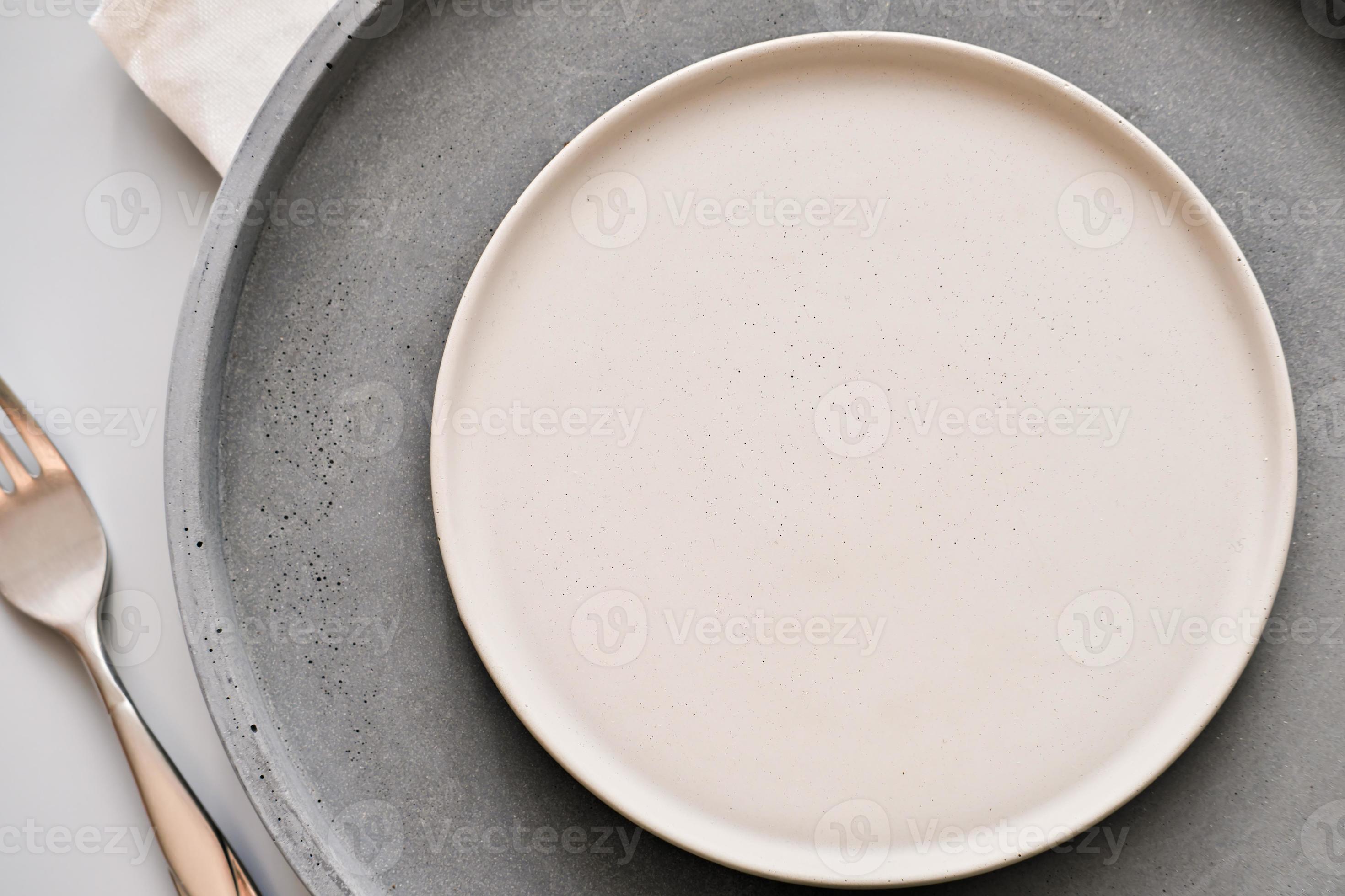 platos grises vac os en una mesa con tenedor y cuchillo. concepto