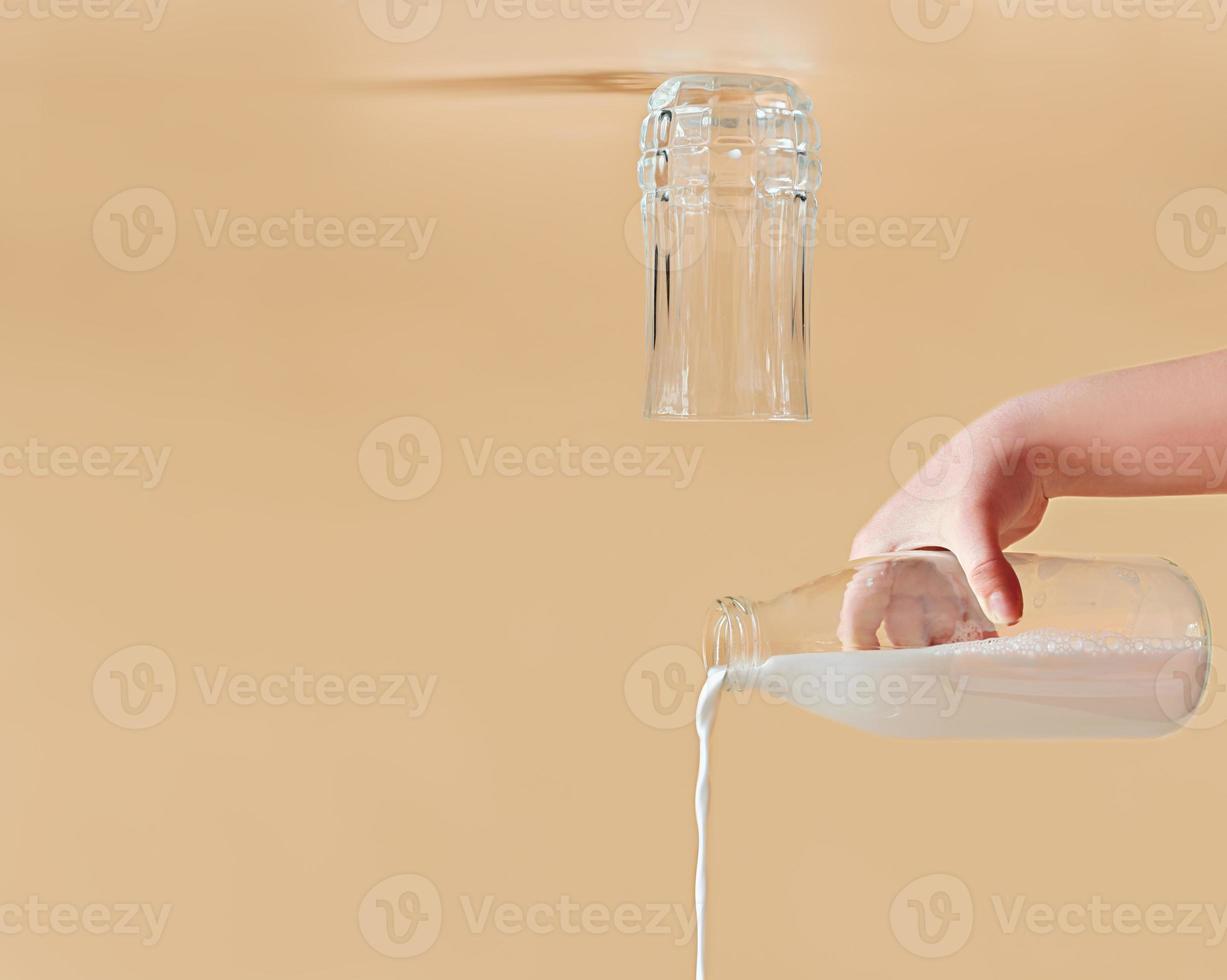 Milk pouring out of a glass bottle. glass turned upside down. creative dairy product concept. copy space photo
