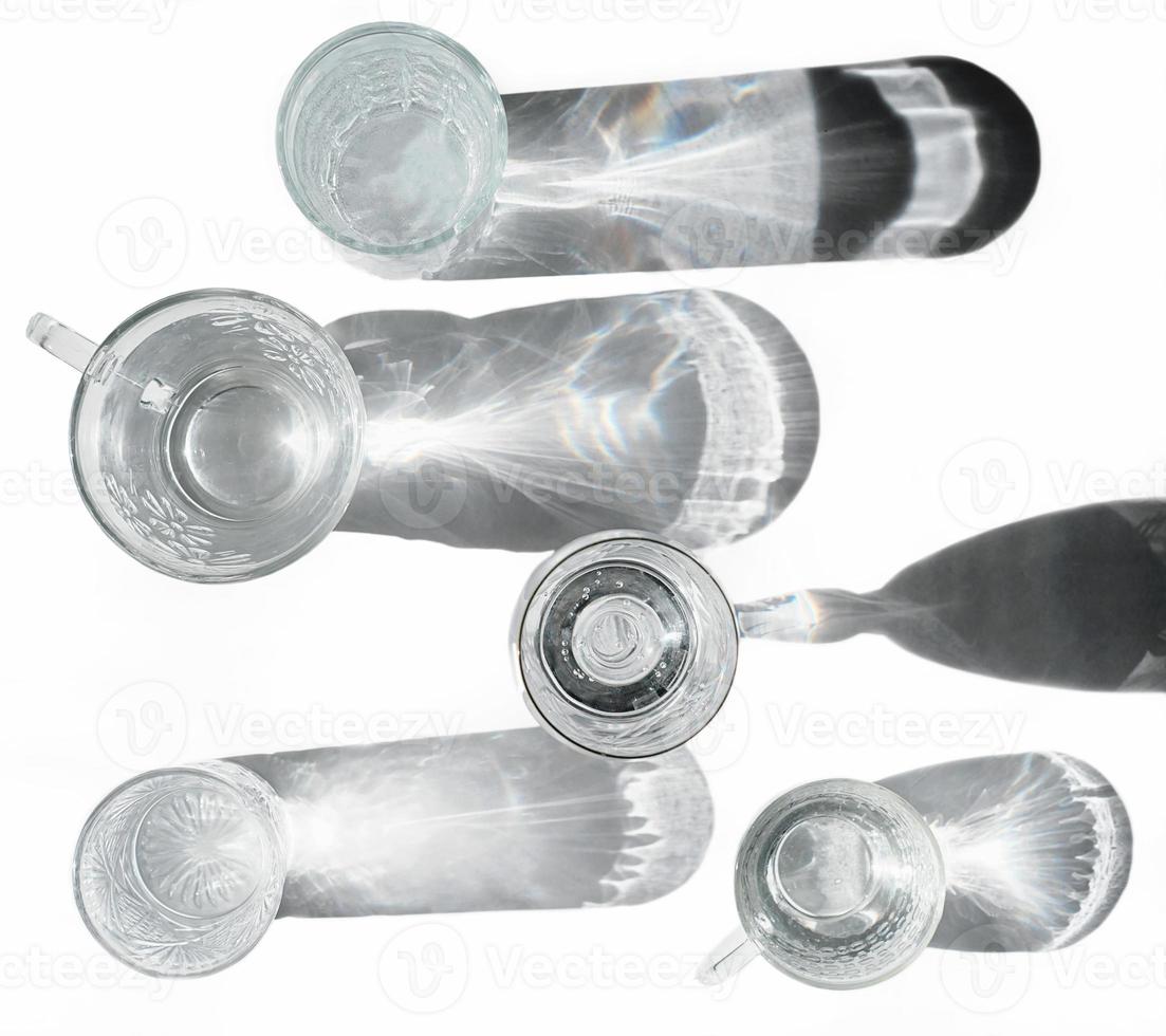 water in various glasses with shadows and reflects. trendy style. top view. diet and detox concept photo