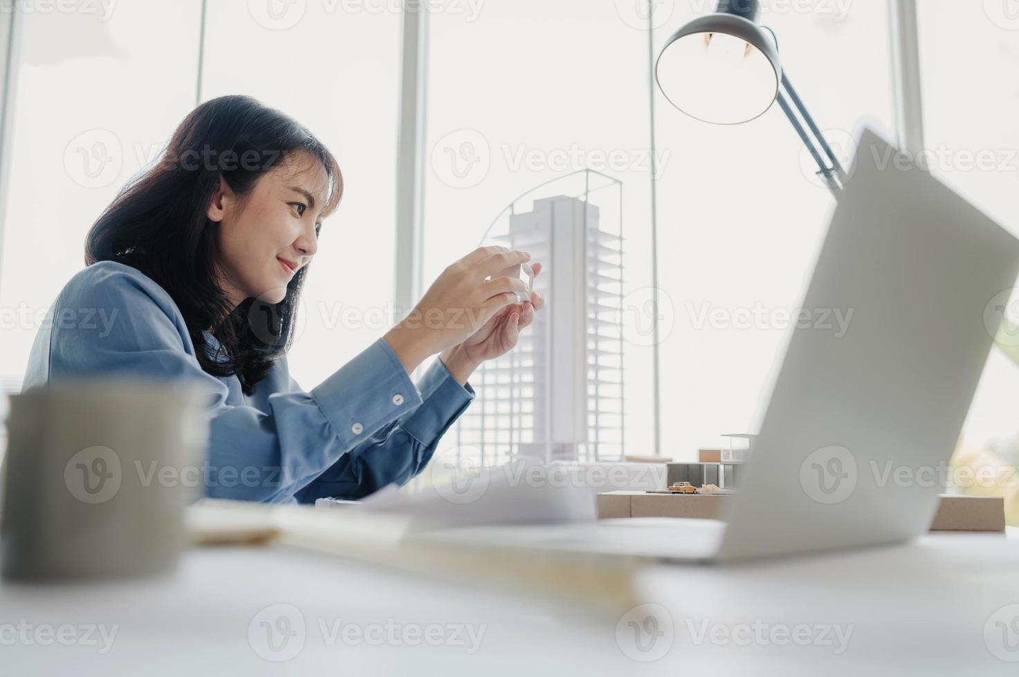 Selective focus, Asian female architect or engineer Currently considering materials for designing modern condominiums. Asian female architect or engineer Sit and analyze, design projects in the office photo