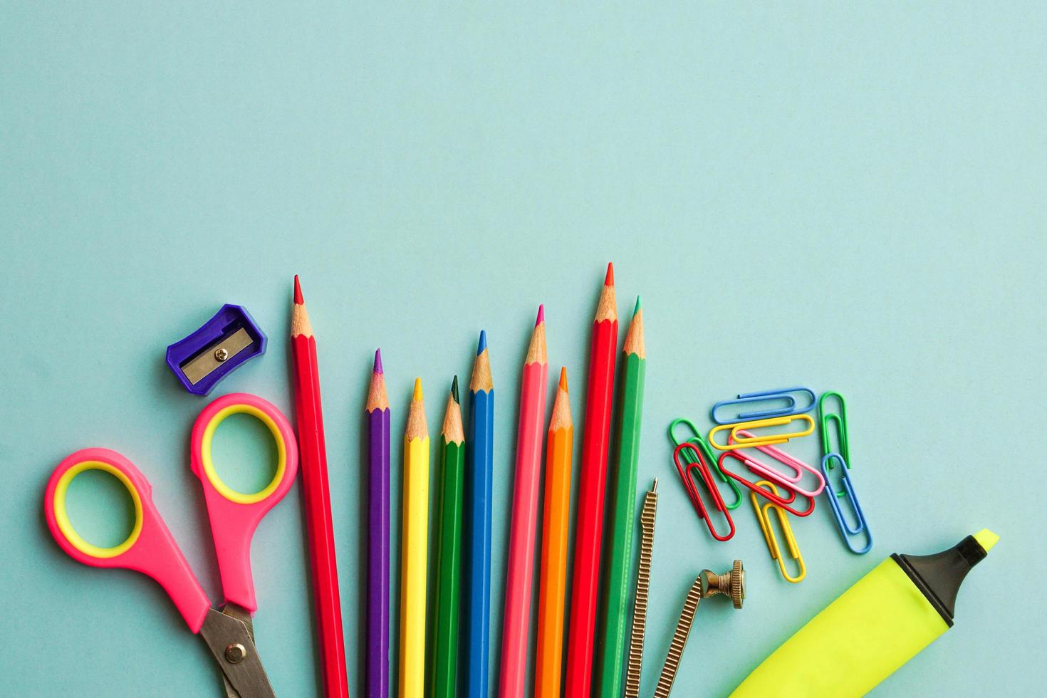 Top view of school supplies and office supplies on blue background. Learning, study, office equipment and presentation concept. photo