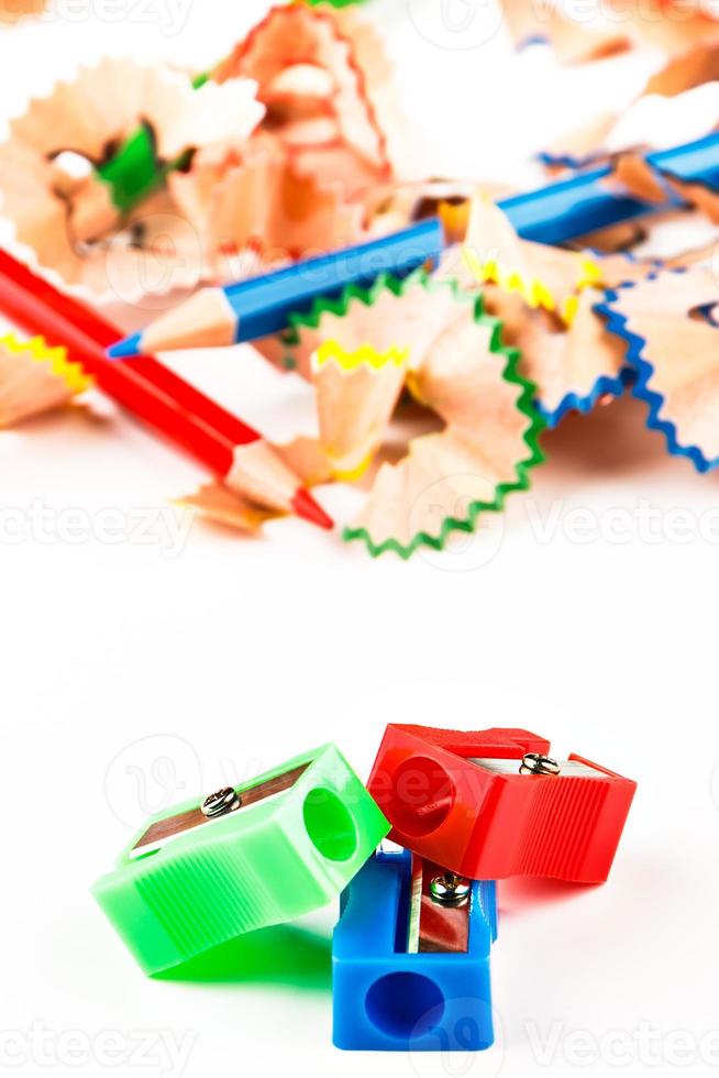 Red, green and blue pencil sharpener with color shavings pencils. Vertical image. photo