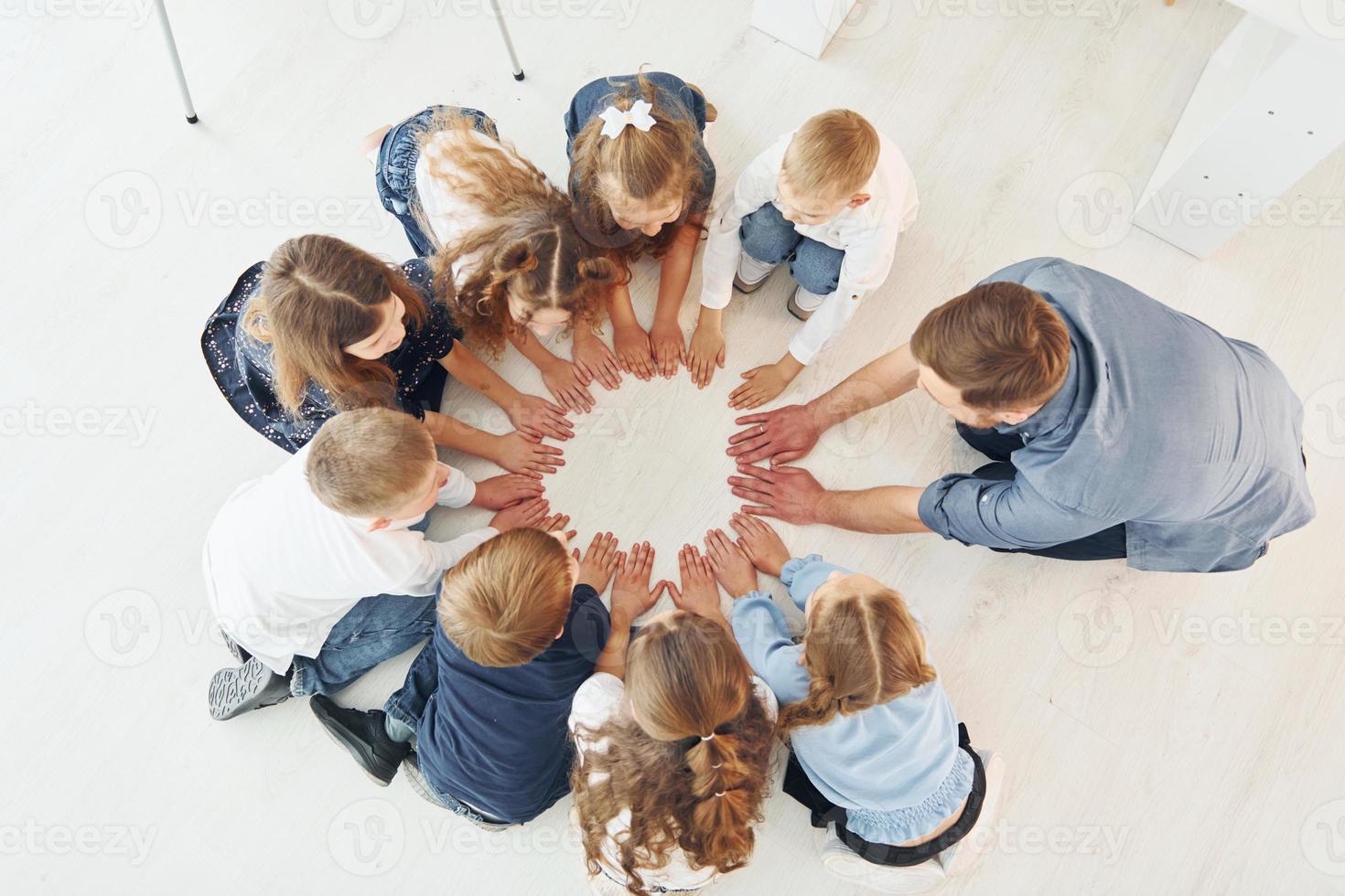 vista superior. hombre con sus hijos estudiantes tomados de la mano para el éxito. concepción de la educación foto