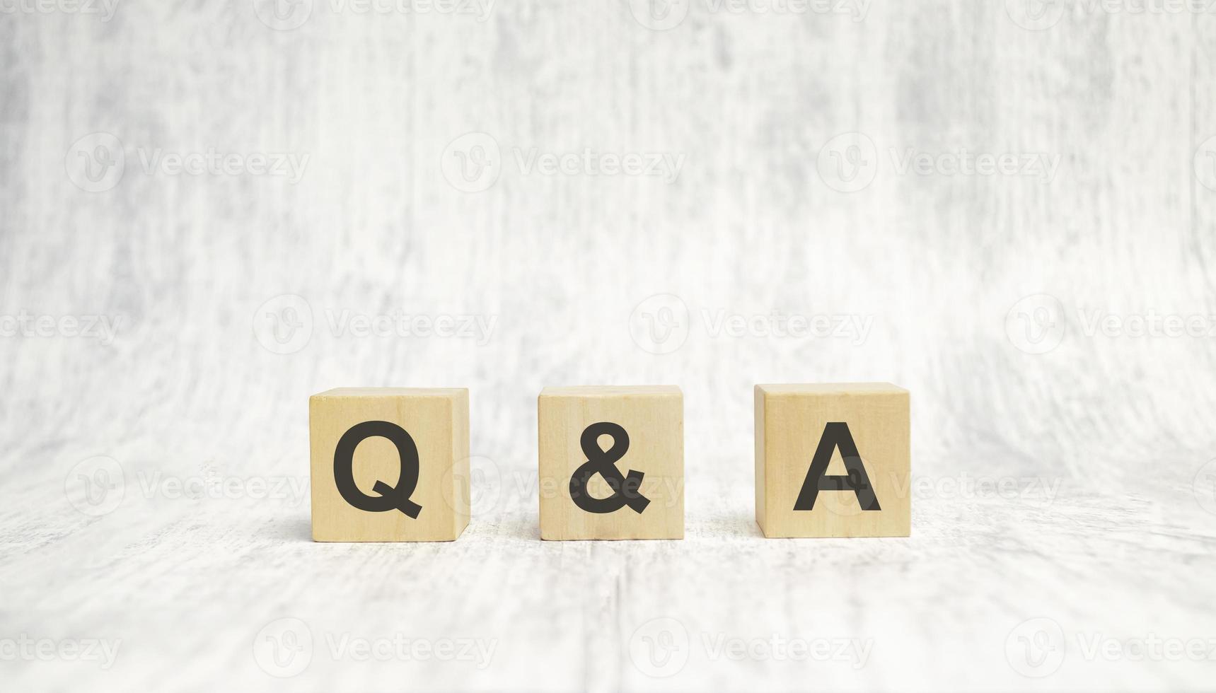 q and a sign on wooden cubes on wooden background photo