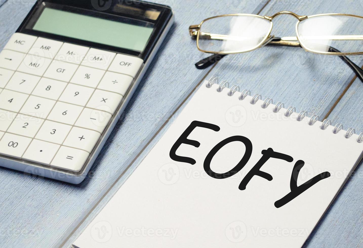 Notepad with text End of Financial Year with calculator and pen photo