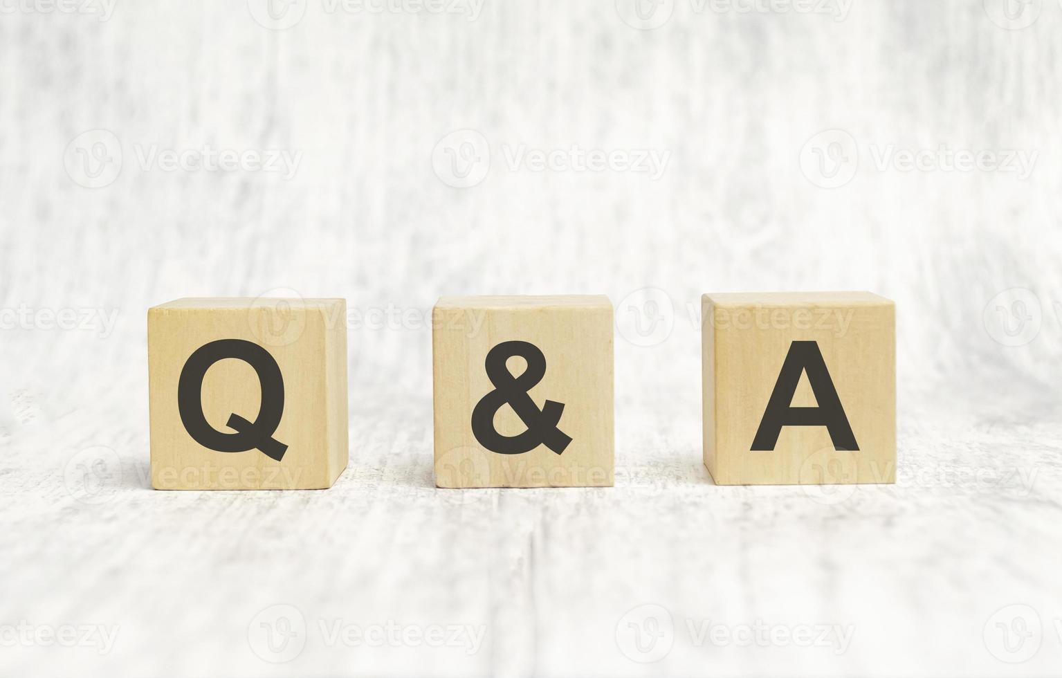 q and a sign on wooden cubes on wooden background photo