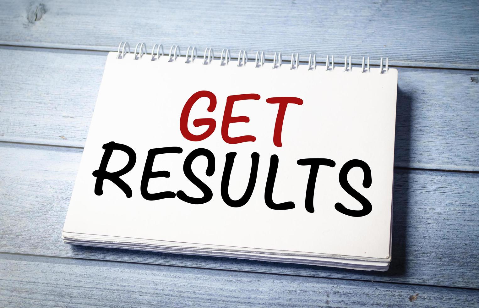get results word notebook on wooden background photo