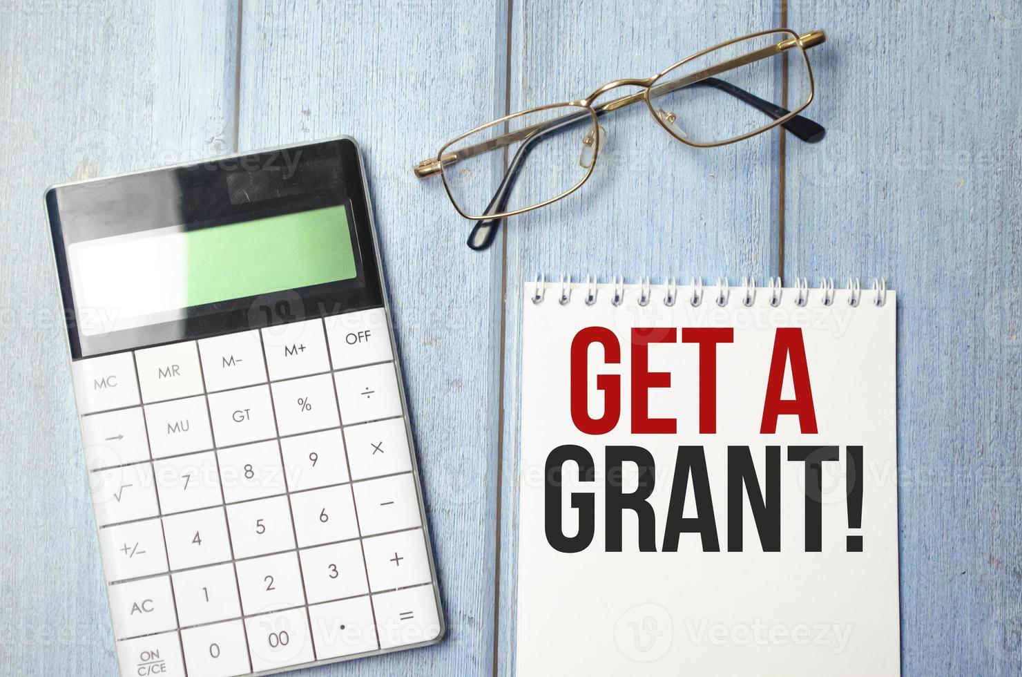 Notepad with text Get a grant with calculator and pen 8390215 Stock