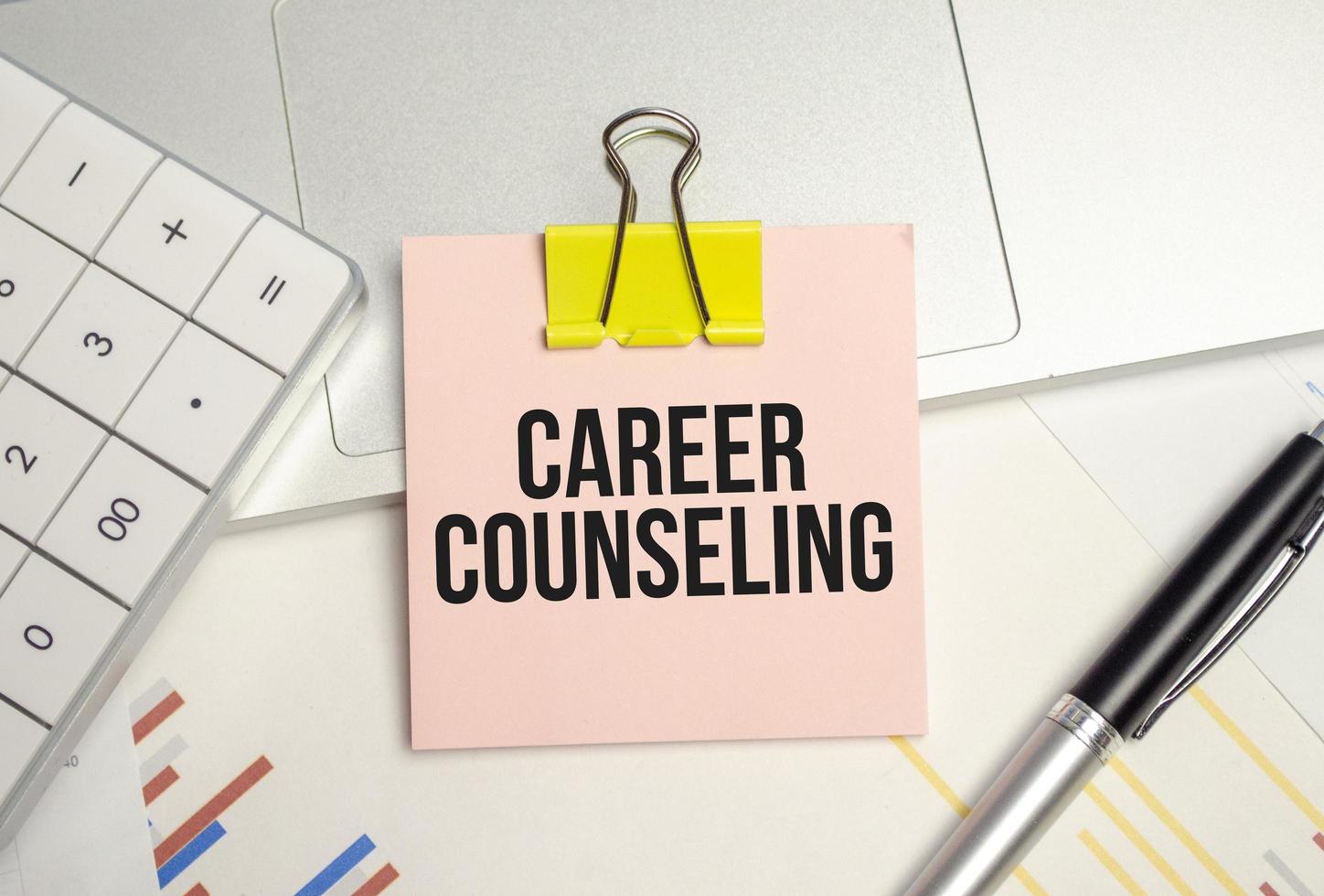 CAREER COUNSELING word on sticker on notepad with pen and calculator photo