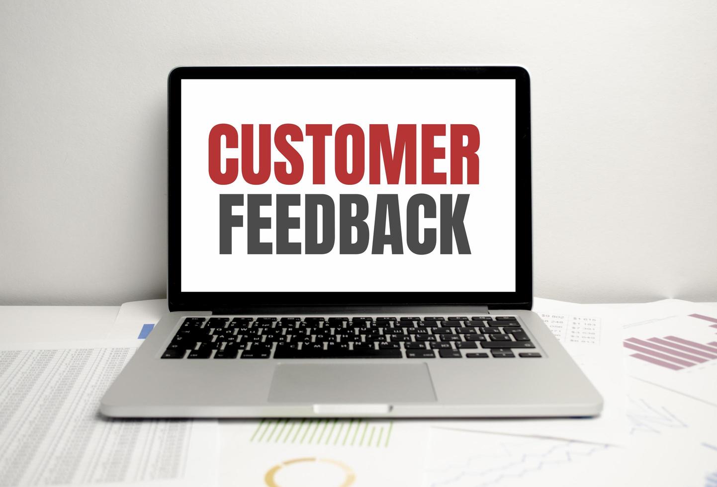 customer feedback words on laptop display and charts photo