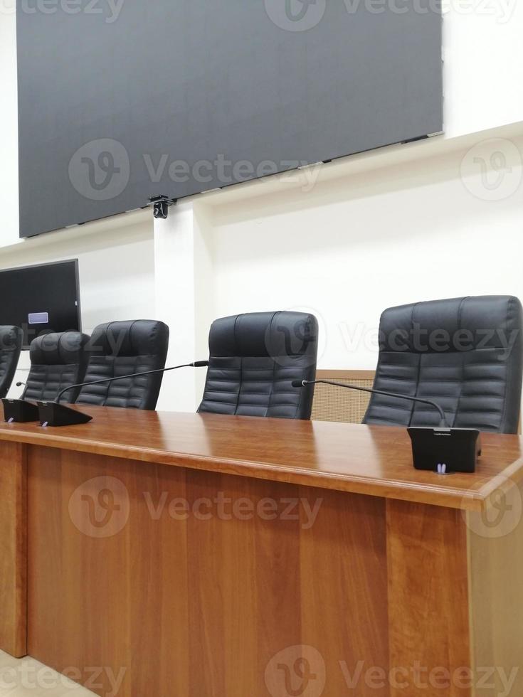 sala de conferencias con sillas vacías y una pantalla de proyección foto