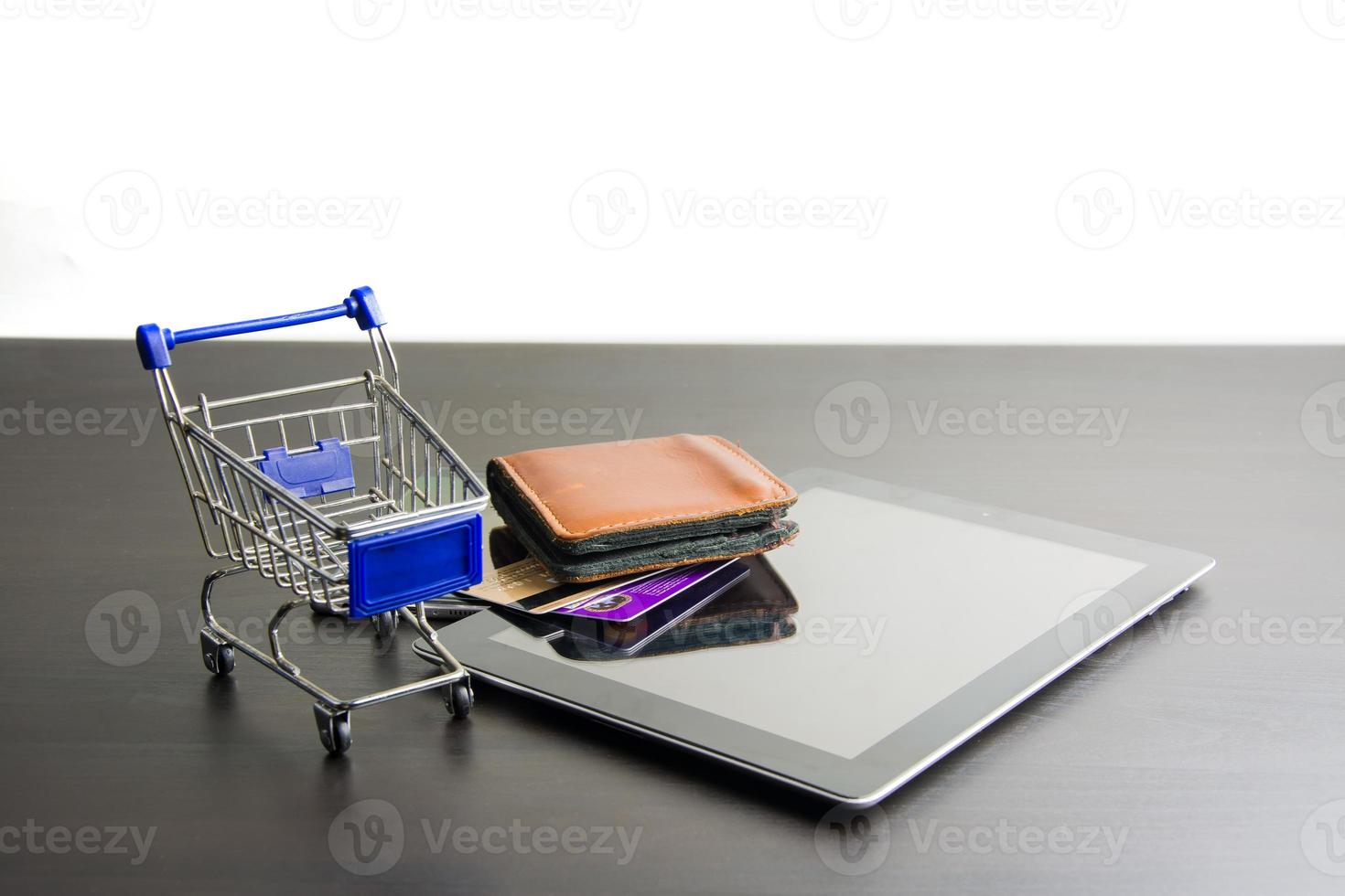 tableta con carrito de compras en madera, significa comprar en línea foto