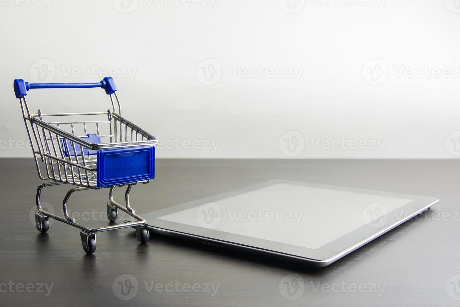 tableta con carrito de compras en madera, significa comprar en línea foto