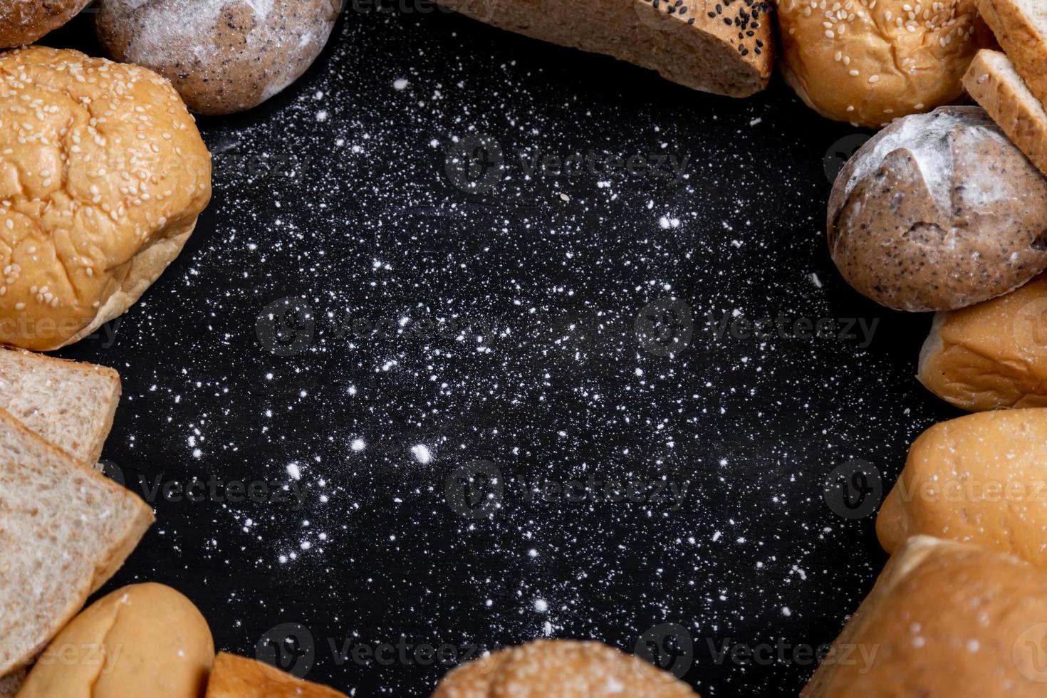 Various kinds of bread placed on the black wooden backgrounds photo