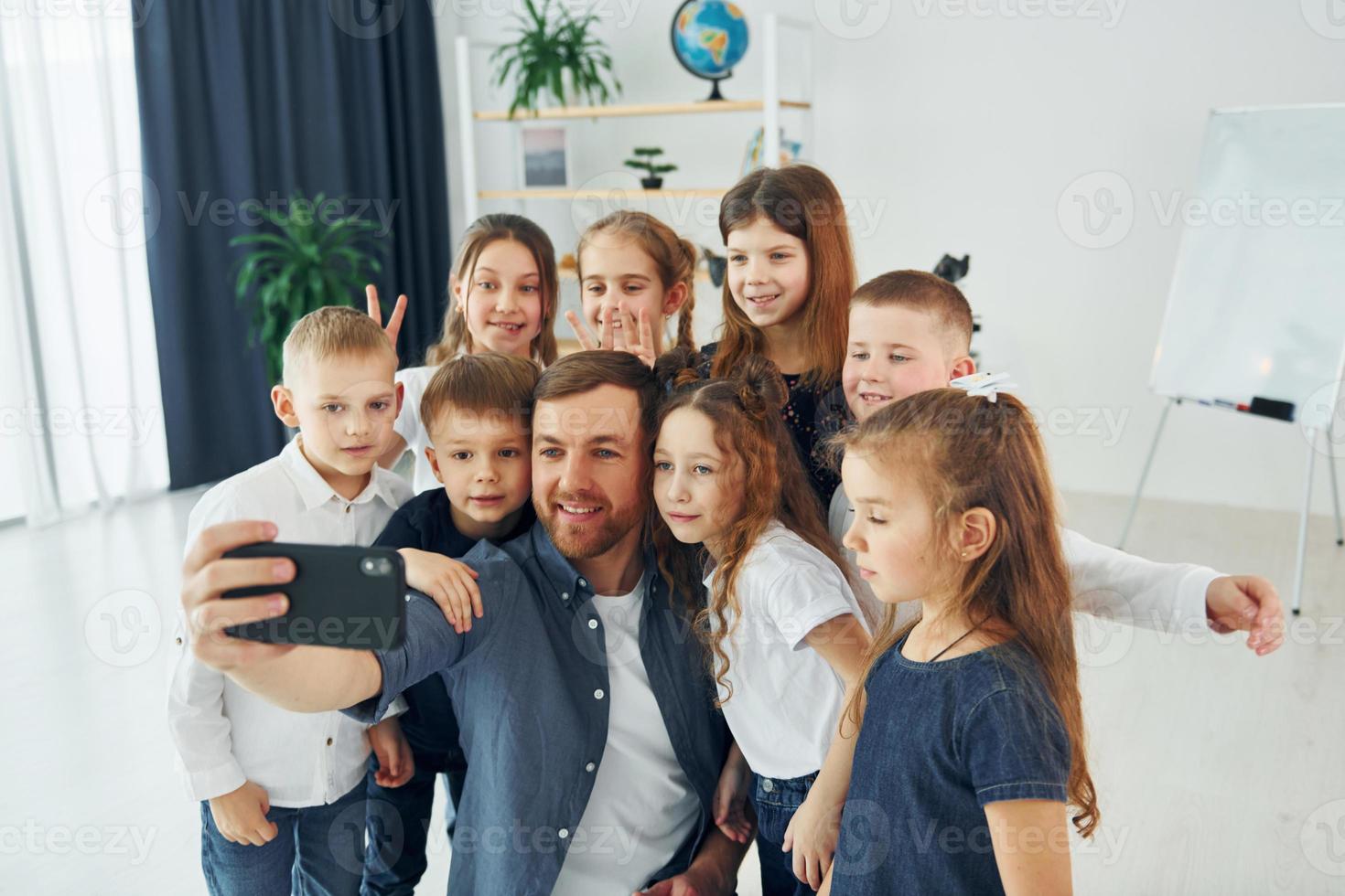 Making a selfie by phone. Group of children students in class at school with teacher photo