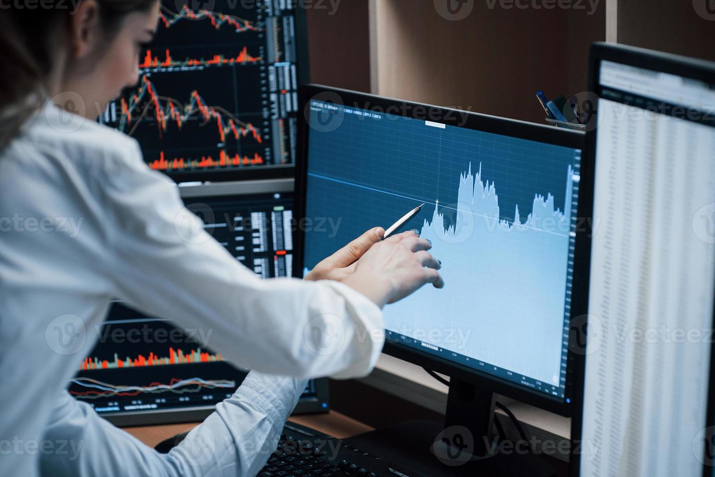 From starting point to complete success of the company. Team of stockbrokers are having a conversation in a office with multiple display screens photo