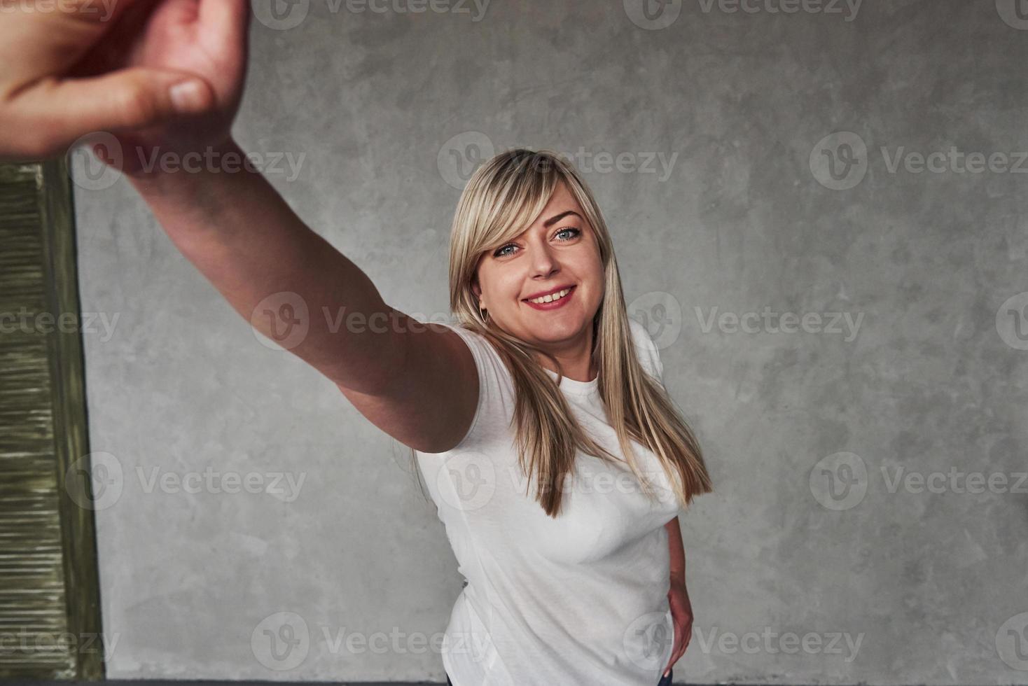 bonita sesión de fotos. joven mujer blanca en el estudio de pie contra el fondo gris foto