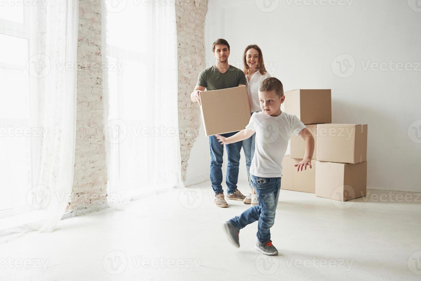 foto en movimiento. estado de ánimo juguetón del niño. la familia tiene mudanza a una nueva casa. desempacar cajas de mudanza