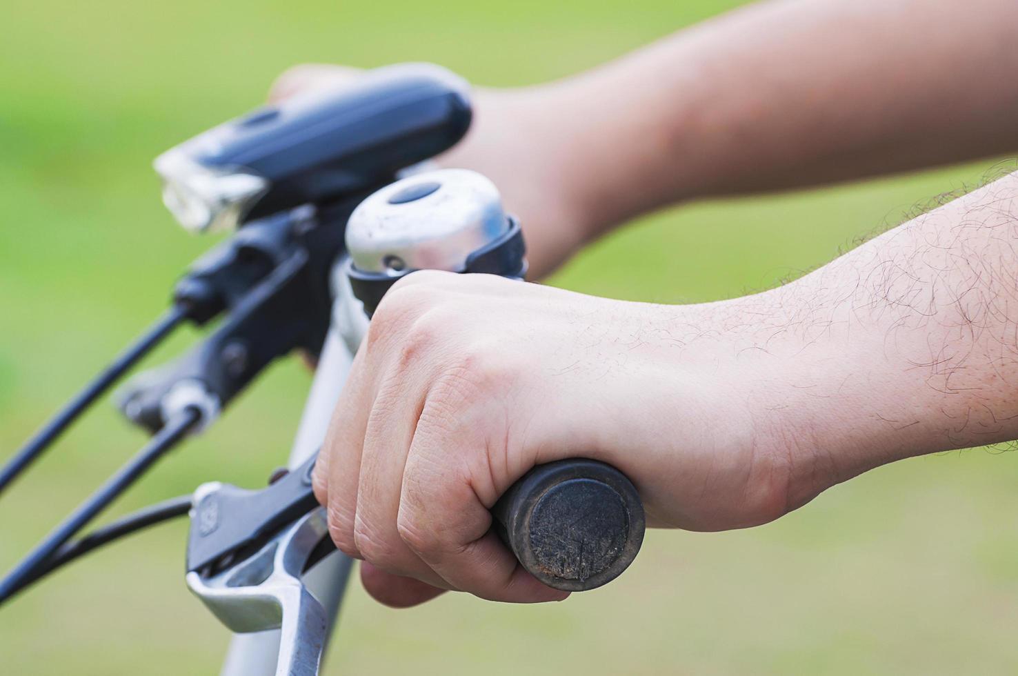 Closeup of boy hand riding bicycle. Photo is focused at nearest hand.