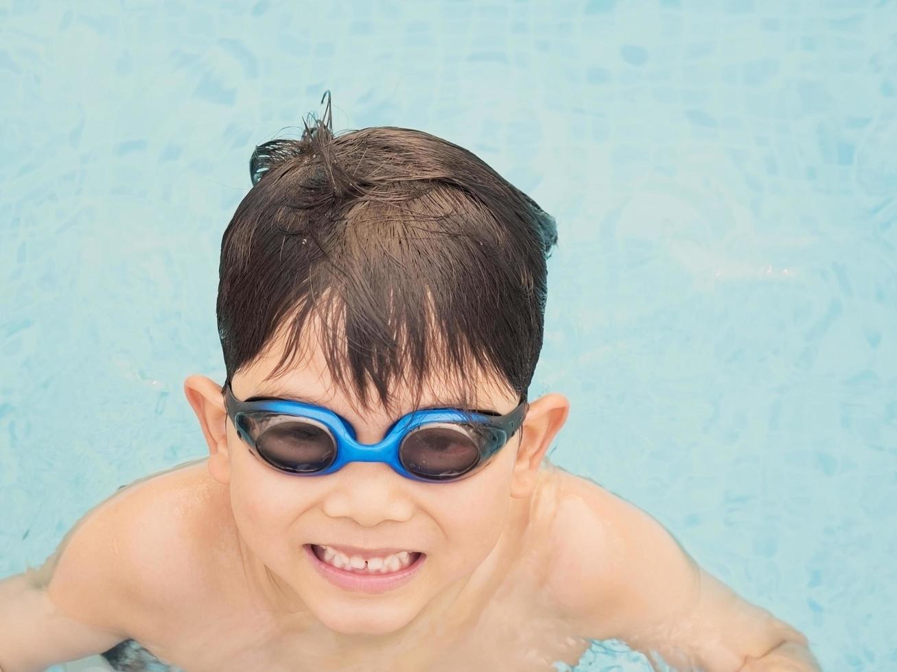 Asian happy kid at the swimming pool photo