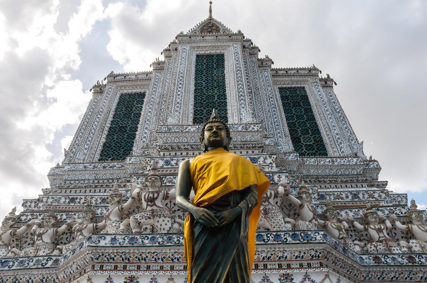 Buddha with temple building background at Wat Arun Ratchawararam Ratchaworamahawiharn, Bangkok, Thailand photo