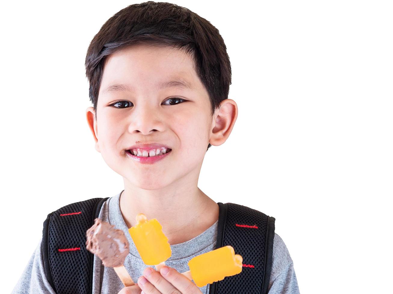 Boy eating ice cream isolated over white background photo
