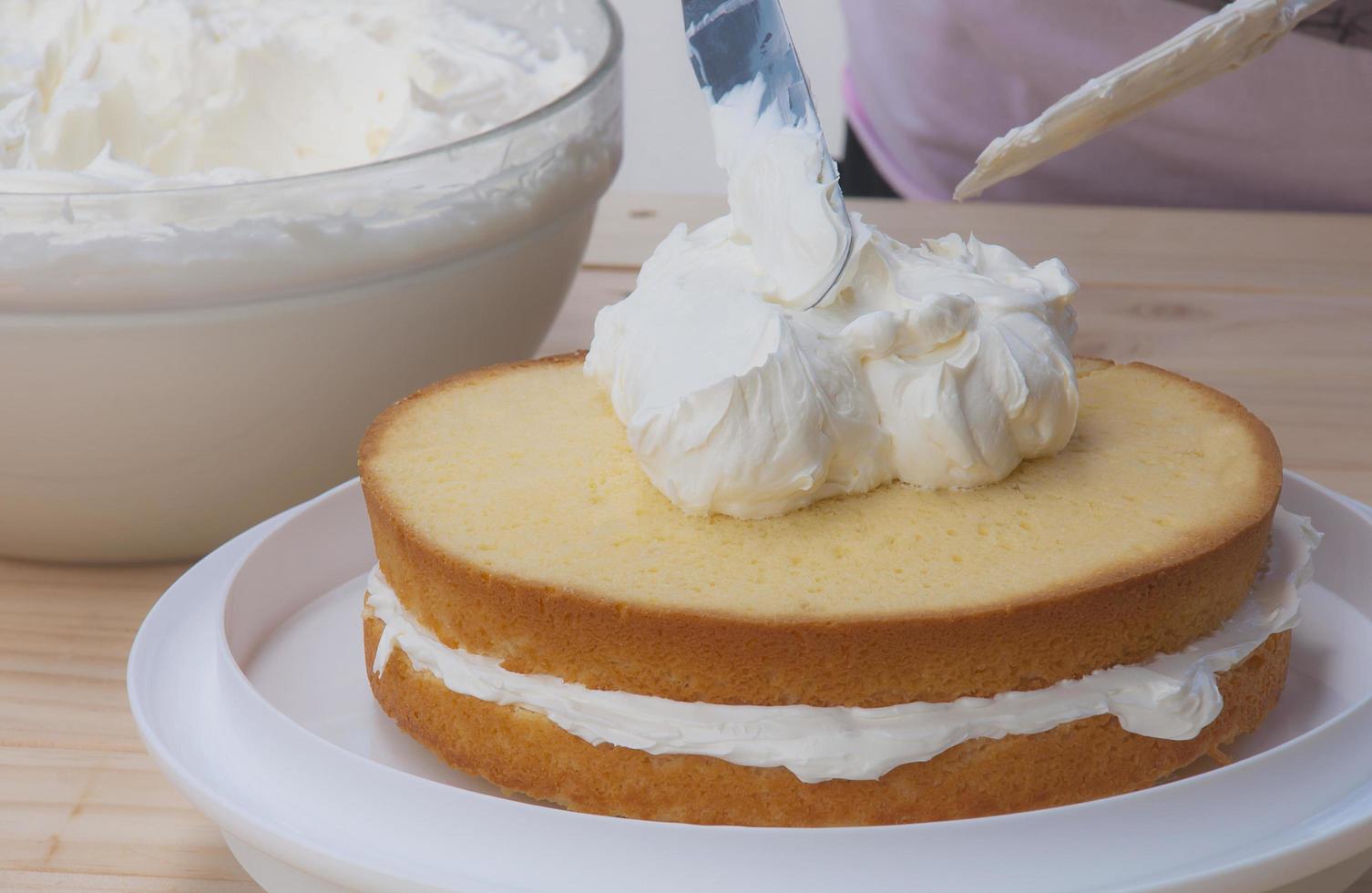 Putting butter  cream cake by hand using spatula photo