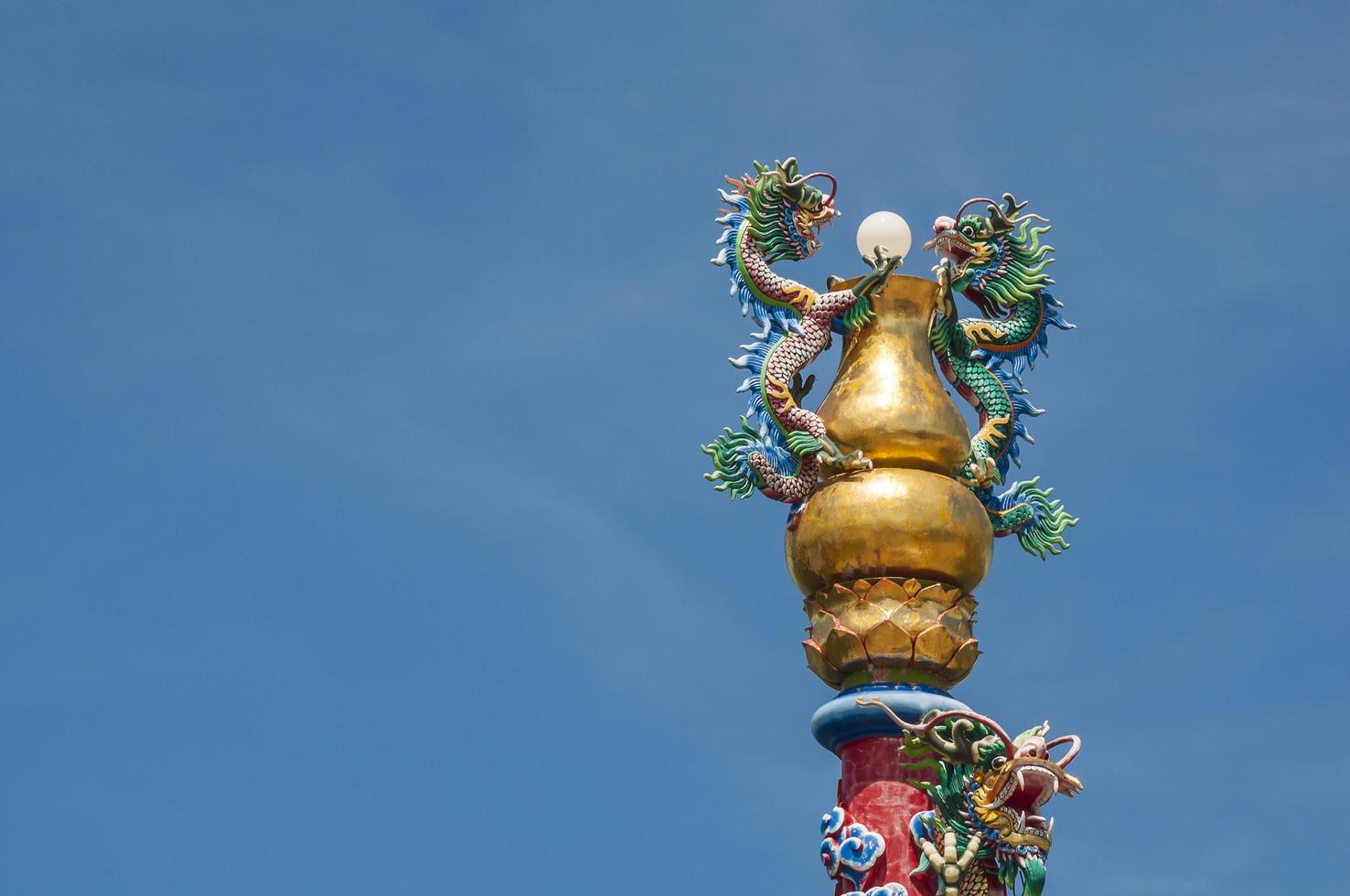 Dragons sculpture on a pillar with blue sky background. Photo is taken from public place Chao Pu-Ya Shrine, Udon Thani Thailand.