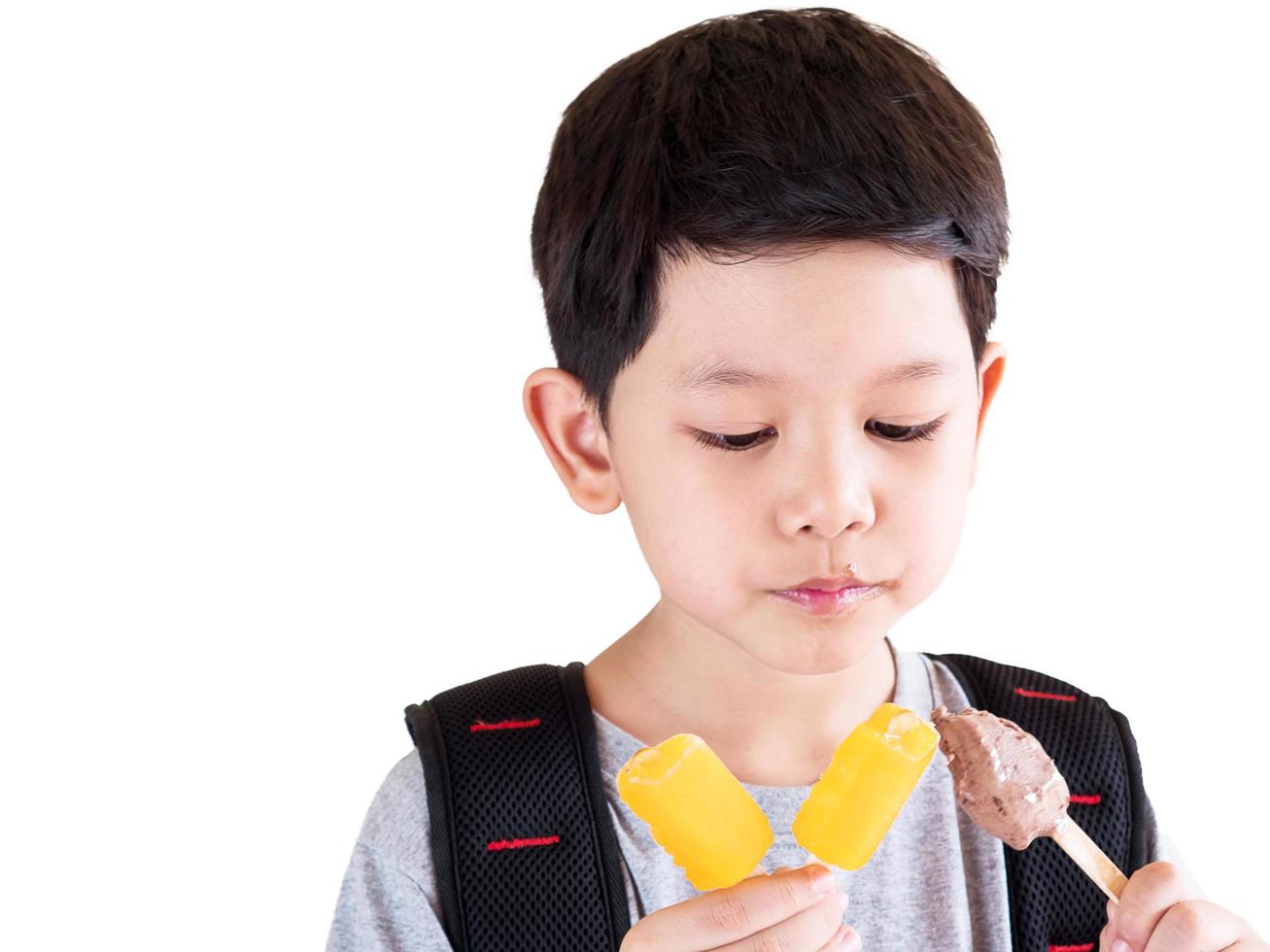 Boy eating ice cream isolated over white background photo
