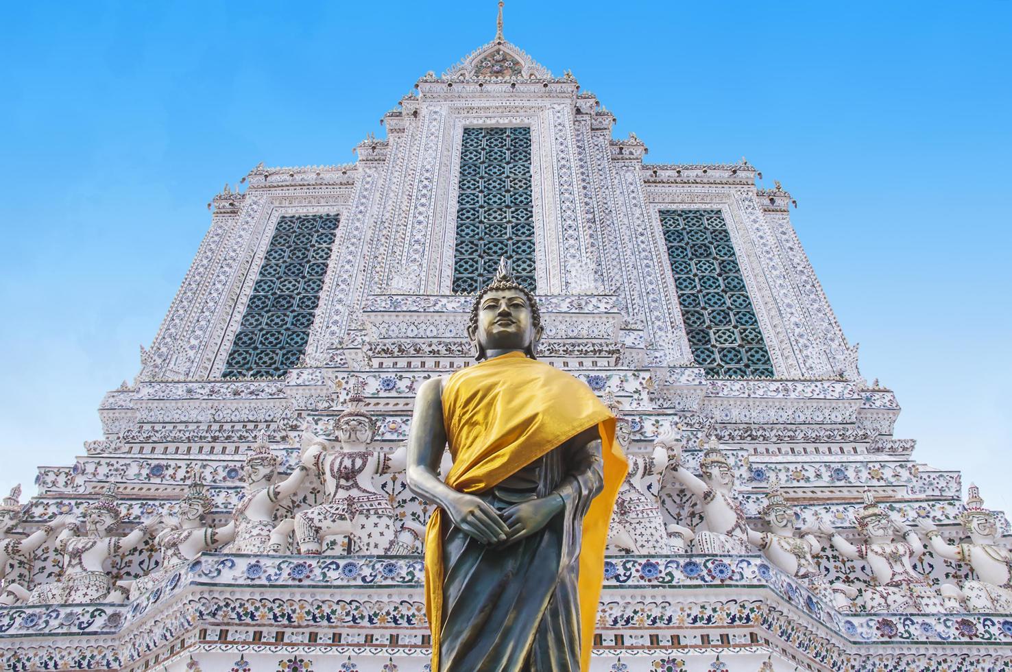 Buddha with temple building background at Wat Arun Ratchawararam Ratchaworamahawiharn, Bangkok, Thailand photo